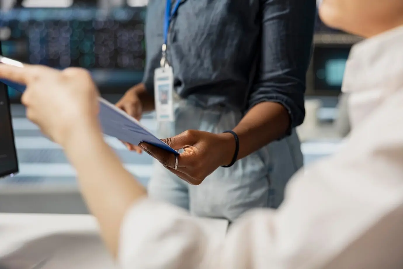 Nahaufnahme von Mitarbeitern im Serverraum, die Dokumentation auf einem Klemmbrett überprüfen.