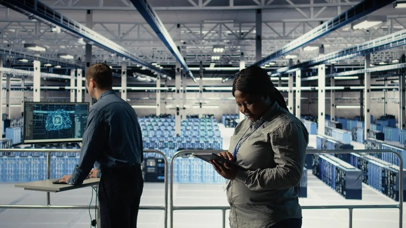 Softwareentwickler, die als Rechenzentrumsmitarbeiter tätig sind, überwachen die Aktivität des Server-Hubs mithilfe eines Tablets.